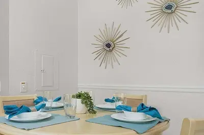 a dining table with blue napkins and plates on it at 2554 RENSHAW ST KISSIMMEE 3BEDS in Orlando