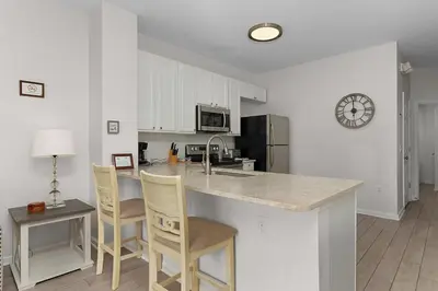 a kitchen with a counter and chairs and a counter top at 2554 RENSHAW ST KISSIMMEE 3BEDS in Orlando