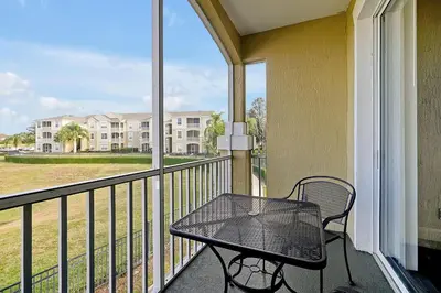 a balcony with a black table and a view of a building at 8105 COCONUT PALM WAY UNIT 205 KISSIMMEE 3BEDS in Kissimmee