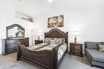 a bedroom with a bed and a couch and a mirror at Pond View Club Cortile Resort Pool Hot Tub Theme in Kissimmee