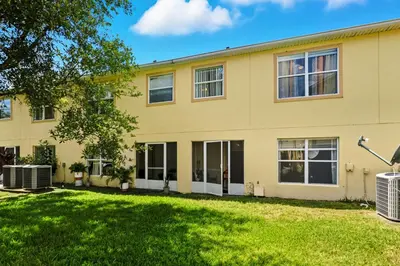 an exterior view of a yellow house with a yard at Pond View Club Cortile Resort Pool Hot Tub Theme in Kissimmee