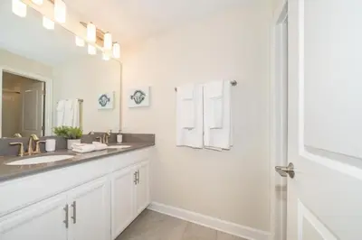 a bathroom with two sinks and a large mirror at Stunning Retreat Townhouse 4 Beds and 10 Mins to Disney With Pool in Kissimmee