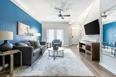 a living room with a couch and a tv at Landing Beautiful 1BD Gym Pool in Orlando