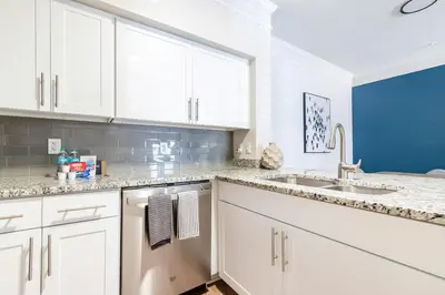 a kitchen with white cabinets and a sink at Landing Beautiful 1BD Gym Pool in Orlando