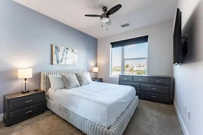 a bedroom with a bed with a ceiling fan and a window at Landing Stylish 1BD Rooftop Lounge Gym in Orlando