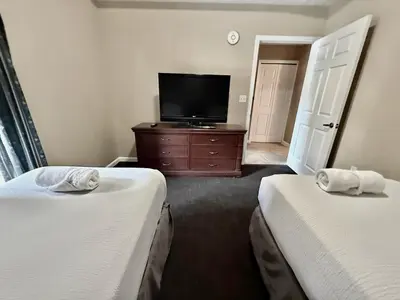 a hotel room with two beds and a flat screen tv at Entire Condo - 3Bed 2Bath- 5 mins to Disney Park in Orlando
