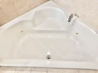 a white bath tub sitting in a bathroom at Entire Condo - 3Bed 2Bath- 5 mins to Disney Park in Orlando