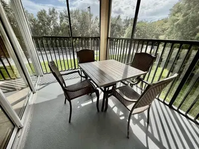 a table and four chairs on a balcony with a table at Entire Condo - 3Bed 2Bath- 5 mins to Disney Park in Orlando