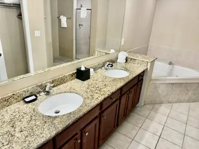 a bathroom with two sinks and a tub at Entire Condo - 3Bed 2Bath- 5 mins to Disney Park in Orlando