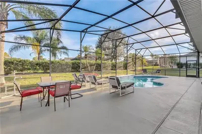 a patio with a table and chairs and a pool at Formosa Villa with Private Pool & 5 Miles to Disney in Orlando