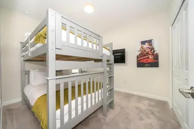 a white bunk bed in a white room with a ladder at Luxo com 6 Quartos e Piscina! – Storey Lake in Kissimmee