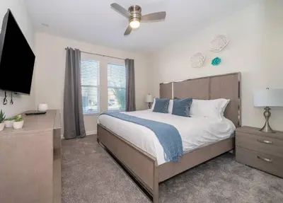 a bedroom with a bed and a ceiling fan at Luxo com 6 Quartos e Piscina! – Storey Lake in Kissimmee