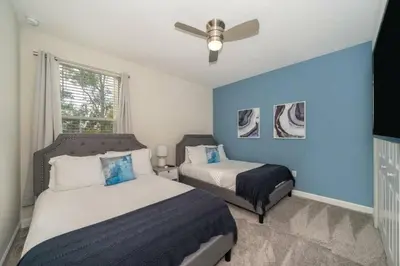 a bedroom with two beds and a ceiling fan at Luxo com 6 Quartos e Piscina! – Storey Lake in Kissimmee