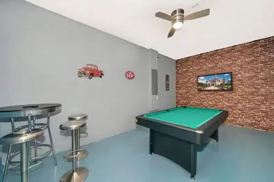 a room with a pool table and a bar with stools at Luxo com 6 Quartos e Piscina! – Storey Lake in Kissimmee