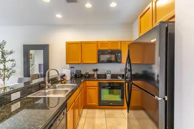 a kitchen with wooden cabinets and a stainless steel refrigerator at 3027 Encantada in Kissimmee