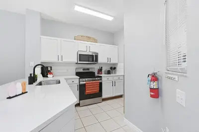 a kitchen with white cabinets and a stove top oven at Private Hot Tub Terra Verde Resort Pool Themed Rooms in Kissimmee