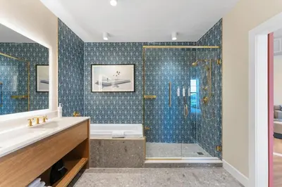 a bathroom with a tub and a shower with blue tiles at 8070-304 Luxury 2BR Apt Kissimmee Orlando Disney in Orlando