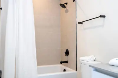 a bathroom with a shower and a toilet and a sink at Beautiful 4-bedroom House with Splash Pool in Orlando
