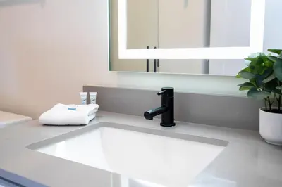 a bathroom sink with a faucet and a mirror at Beautiful 4-bedroom House with Splash Pool in Orlando