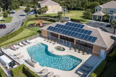 an aerial view of a house with a pool with solar panels at Beautiful 4-bedroom House with Splash Pool in Orlando