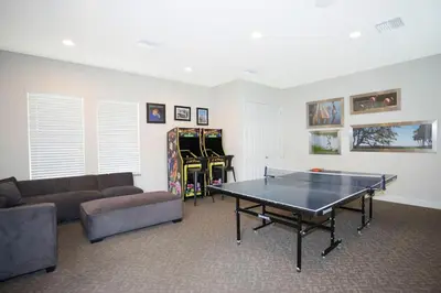 a living room with a ping pong table and a couch at Beautiful 4-bedroom House with Splash Pool in Orlando