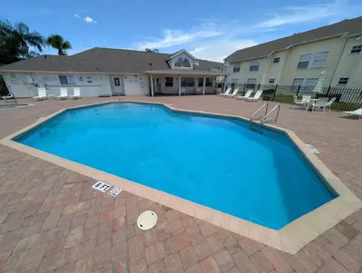 a large blue swimming pool in front of a building at Great for Families 1-4 Kids! Near Disney, Universal, Shopping, Dining in Kissimmee