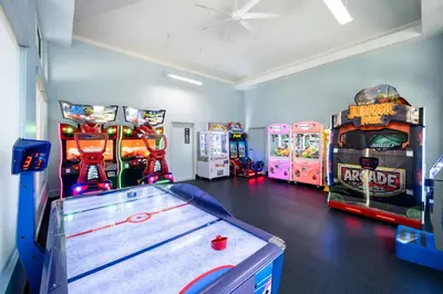 a room with three arcade games and a table at SpringHill Suites by Marriott Orlando at FLAMINGO CROSSINGS Town Center-Western Entrance in Orlando