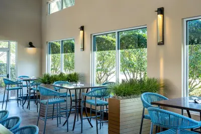 a restaurant with tables and chairs and windows at SpringHill Suites by Marriott Orlando at FLAMINGO CROSSINGS Town Center-Western Entrance in Orlando