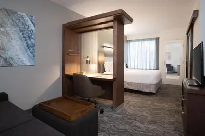 a hotel room with a desk and a bed at SpringHill Suites by Marriott Orlando at FLAMINGO CROSSINGS Town Center-Western Entrance in Orlando