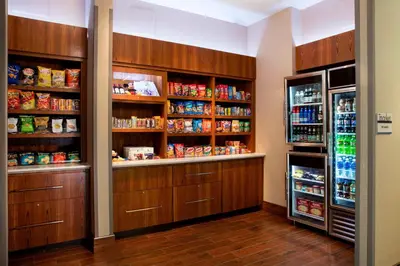 a pantry with wooden cabinets and a refrigerator at SpringHill Suites by Marriott Orlando at FLAMINGO CROSSINGS Town Center-Western Entrance in Orlando