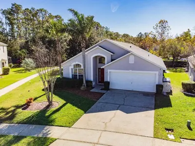 a house with a driveway and a garage at Casa Térrea 5Q c/ Piscina — 15min da Disney in Kissimmee