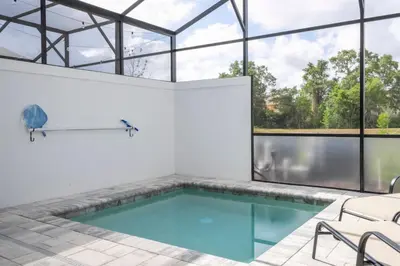 an indoor pool with glass windows and a swimming pool at Stylish Property with Private Pool in Orlando