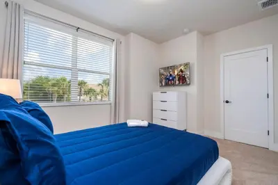 a bedroom with a blue bed and a window at Stylish Property with Private Pool in Orlando