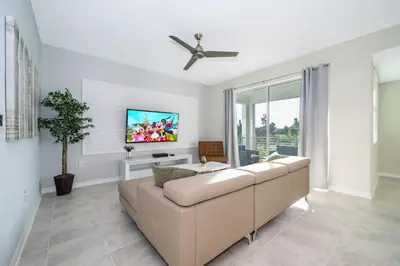 a living room with a couch and a tv at Modern Condo Near Disney in Kissimmee