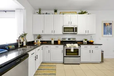 a white kitchen with white cabinets and appliances at Windsor Hills Family Paradise in Orlando