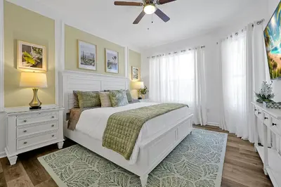 a bedroom with a white bed and a ceiling fan at Windsor Hills Family Paradise in Orlando