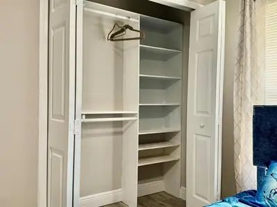 a walk in closet with white doors and shelves at Modern 4BR 2BA with pool in gated community in Kissimmee