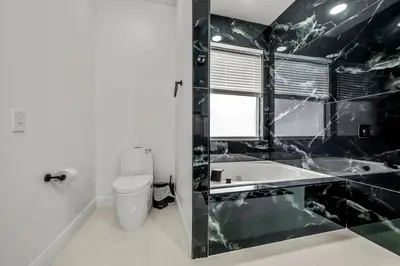 a black and white bathroom with a sink and a toilet at Luxury Disney Retreat in Kissimmee
