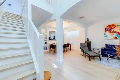 a living room with a staircase and a dining room at EIR2706 - 7B Lakefront Resort 8 min to Disney in Kissimmee
