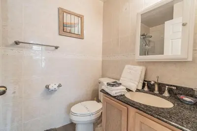 a bathroom with a toilet and a sink and a mirror at 5Q/3B Vista p/ Lago *Piscina Priv.* in Kissimmee