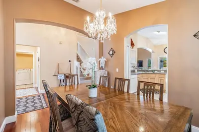 a dining room and kitchen with a table and chairs at 5Q/3B Vista p/ Lago *Piscina Priv.* in Kissimmee