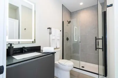 a bathroom with a toilet and a glass shower at Modern 3Bd Screened Pool at Serenity Resort 17322 in Orlando