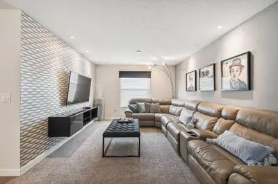 a living room with a leather couch and a flat screen tv at Casa Luxo Storey Lake | 6 quartos + Piscina in Kissimmee