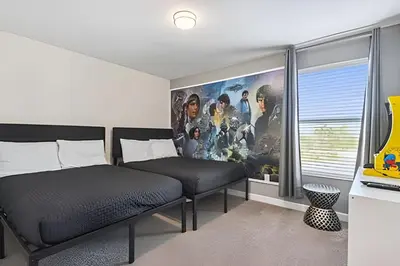 a bedroom with two beds and a poster of a movie at Casa Luxo Storey Lake | 6 quartos + Piscina in Kissimmee