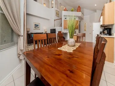 a dining room and kitchen with a wooden table and chairs at WP8167SPD – Spacious 6-Bed Oasis with Pool near Disney in Kissimmee
