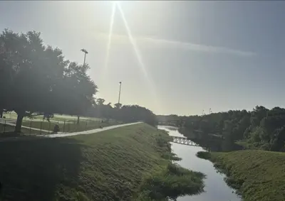 a river in a field next to a road at 10 Minutes from Universal - Relaxing Guest Suite in Orlando
