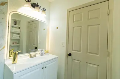 a bathroom with a white sink and a mirror at 10 Minutes from Universal - Relaxing Guest Suite in Orlando