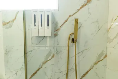 a shower in a bathroom with white marble walls at 10 Minutes from Universal - Relaxing Guest Suite in Orlando