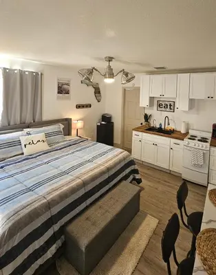 a bedroom with a large bed and a kitchen at 10 Minutes from Universal - Relaxing Guest Suite in Orlando