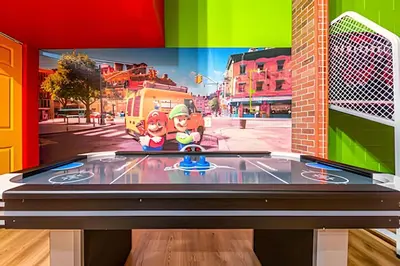 a ping pong table with a video game on it at Windsor Hills 4Q c Piscina + Game Room Mario in Orlando